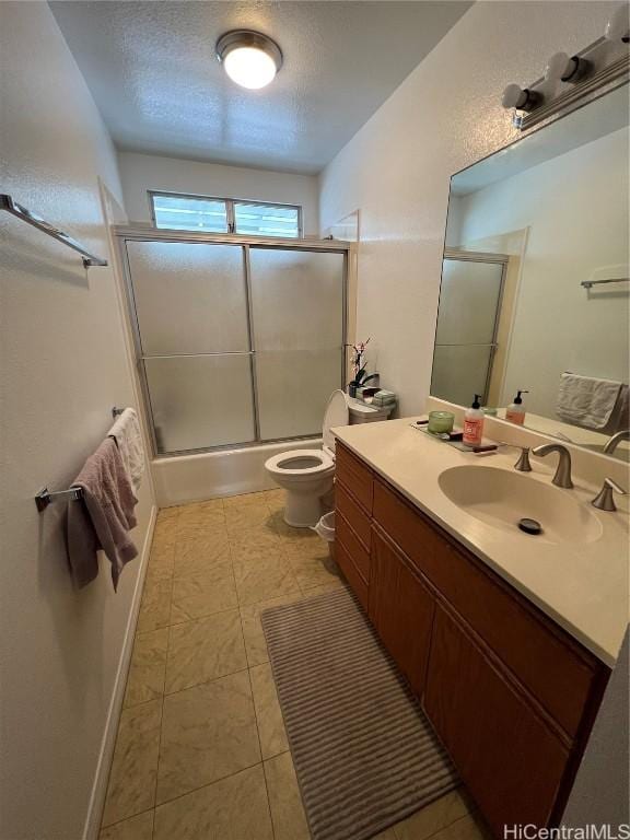 full bathroom with bath / shower combo with glass door, toilet, vanity, and a textured ceiling