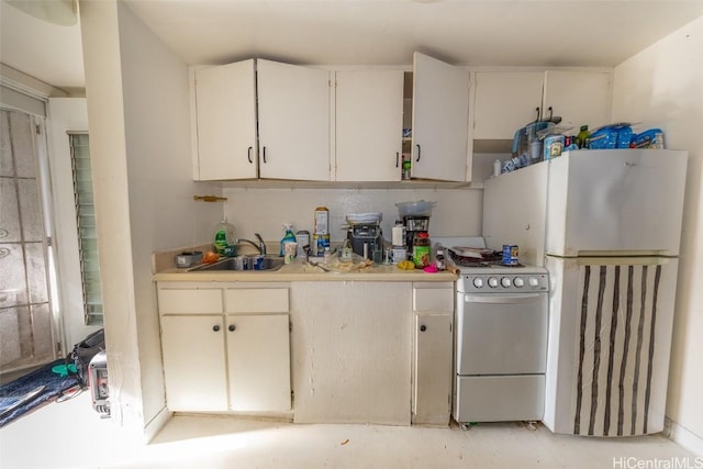 kitchen with white appliances, white cabinetry, and sink