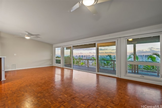 unfurnished living room featuring ceiling fan and parquet flooring