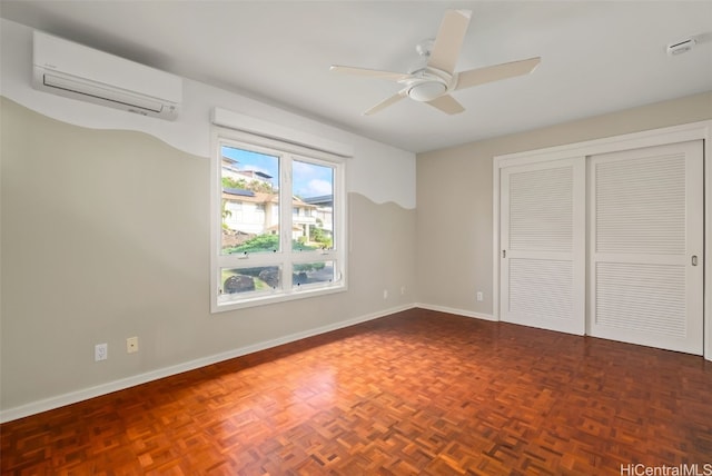 unfurnished bedroom with ceiling fan, dark parquet flooring, an AC wall unit, and a closet