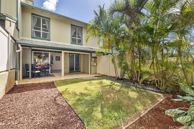 rear view of property with a lawn and a patio