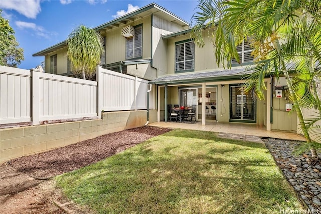 rear view of property featuring a patio area and a lawn