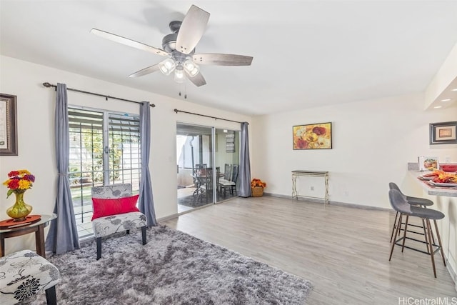 living area with light hardwood / wood-style floors and ceiling fan