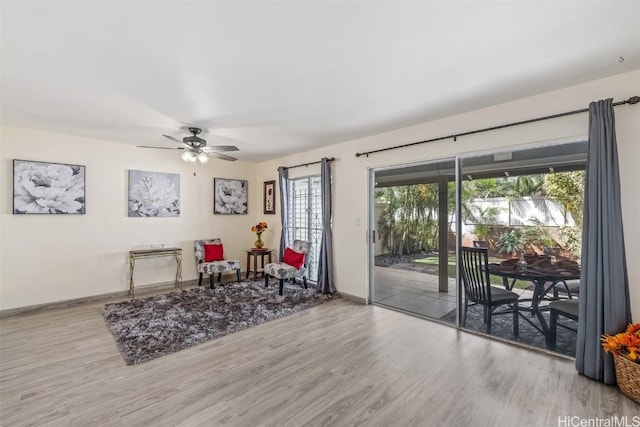 living area with ceiling fan and wood-type flooring