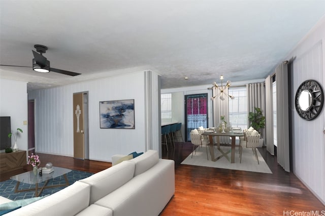 living room with dark wood-type flooring and ceiling fan with notable chandelier