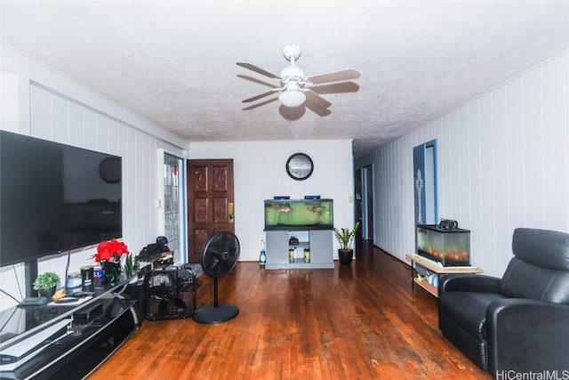 living room featuring ceiling fan, dark hardwood / wood-style flooring, and a textured ceiling