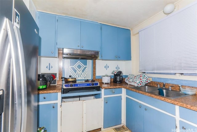 kitchen featuring blue cabinetry, stainless steel fridge with ice dispenser, cooktop, and sink