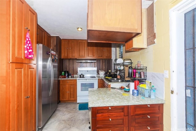 kitchen with white electric range oven, ventilation hood, stainless steel refrigerator, and sink