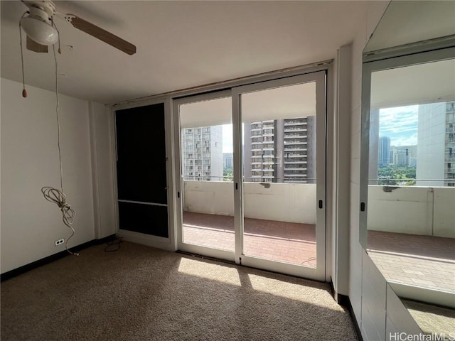 doorway with ceiling fan and carpet floors