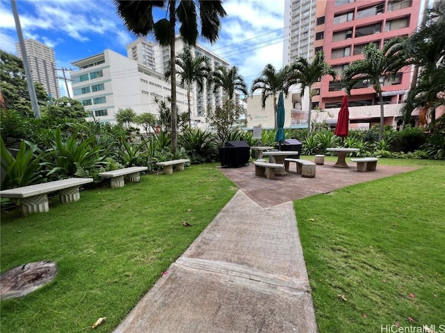 view of community with a lawn and a patio area