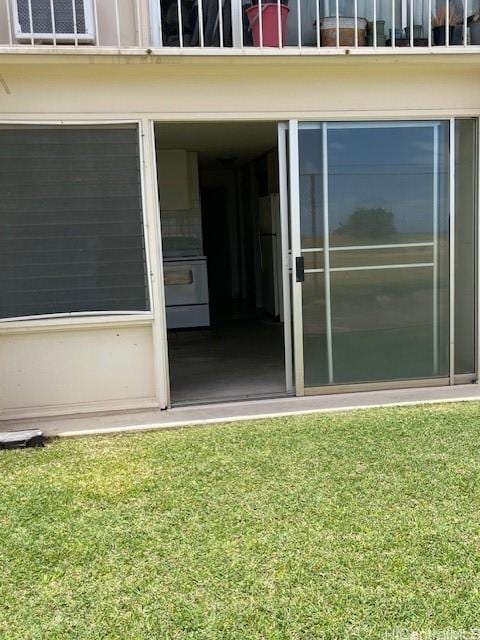 entrance to property featuring a lawn