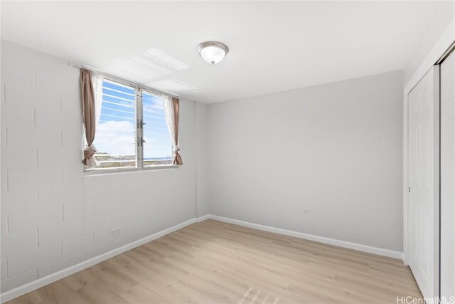 unfurnished bedroom featuring light wood-type flooring and a closet