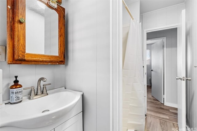 bathroom featuring a shower with shower curtain, wood finished floors, and vanity