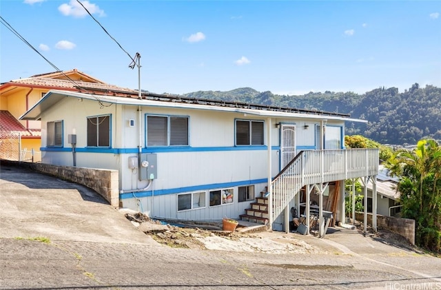 view of front of property with stairway and a mountain view