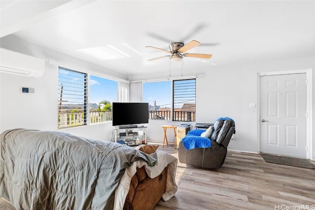 living room with a ceiling fan, light wood-style flooring, and a wall mounted AC