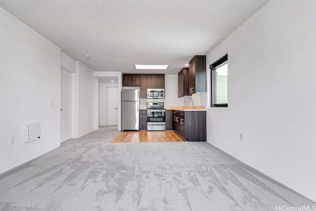 615 Keawe St Unit 406, Honolulu, HI 96813 - kitchen with stainless steel appliances, sink, a textured ceiling, light carpet, and dark brown cabinetry