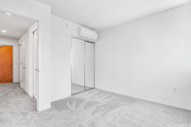 615 Keawe St Unit 406, Honolulu, HI 96813 - carpeted bedroom featuring a closet, an AC wall unit, and a textured ceiling