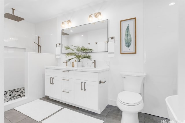 bathroom featuring tile patterned flooring, vanity, toilet, and tiled shower