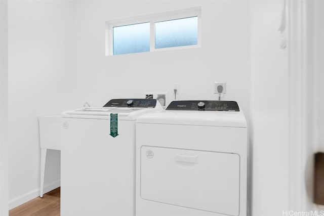 laundry room featuring washer and dryer, light wood-type flooring, baseboards, and laundry area