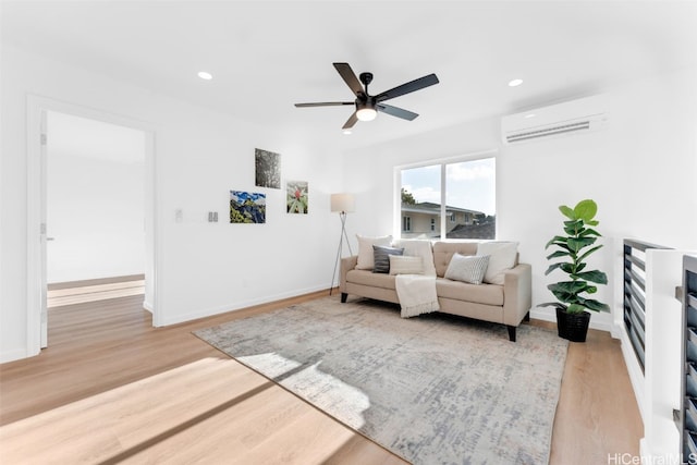 sitting room featuring baseboards, recessed lighting, an AC wall unit, and light wood-style floors