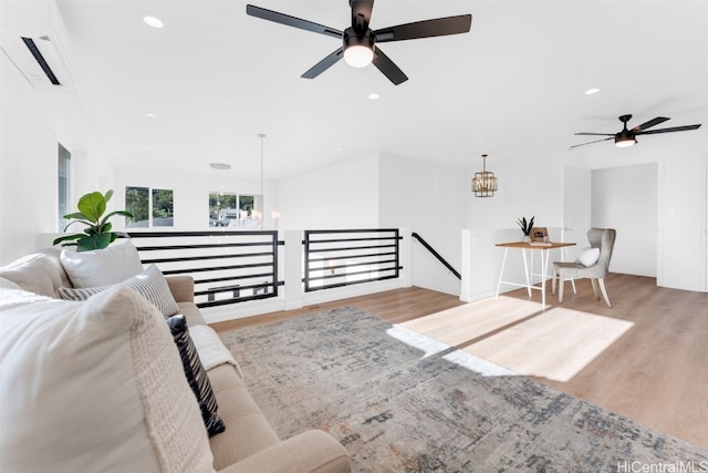 living area featuring recessed lighting, wood finished floors, a wall mounted air conditioner, and a chandelier