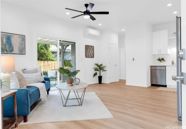 living room with a wall mounted air conditioner, light hardwood / wood-style floors, and ceiling fan