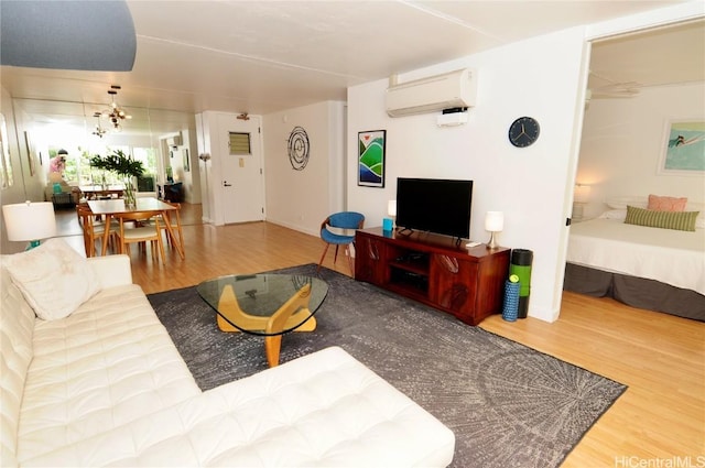 living room featuring wood-type flooring and a wall unit AC