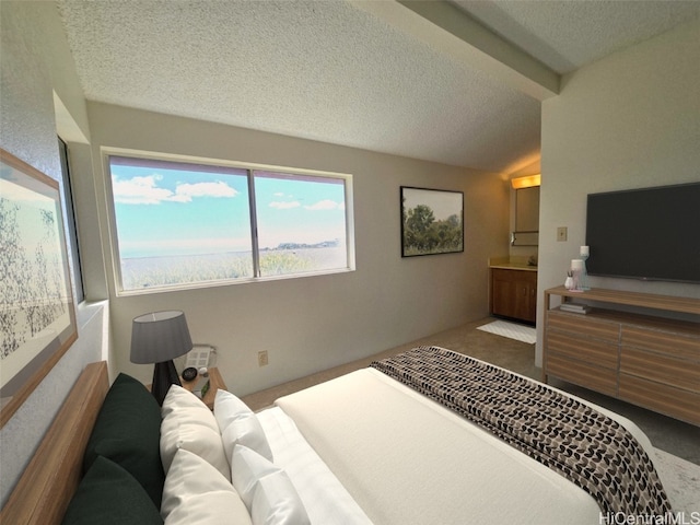 bedroom featuring ensuite bath, carpet, lofted ceiling, and a textured ceiling