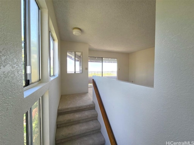 stairs featuring a textured ceiling