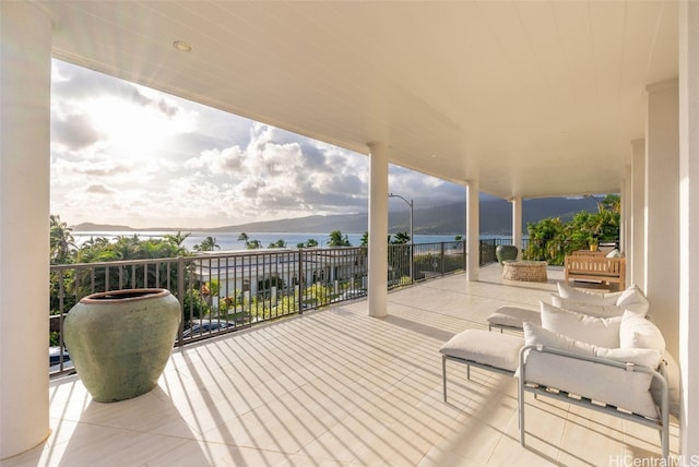 view of patio / terrace with a water and mountain view and a balcony