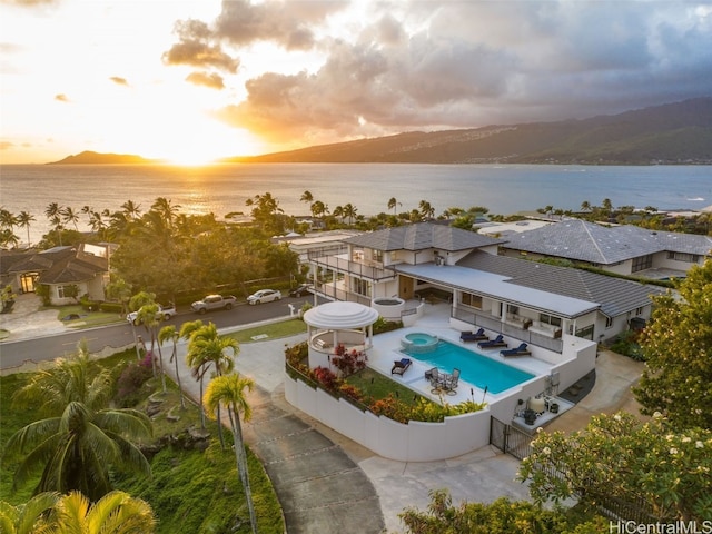 aerial view at dusk featuring a water view