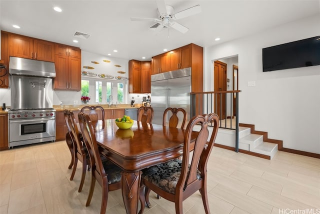 dining room with ceiling fan and sink