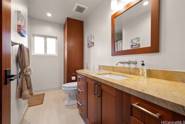 bathroom with tile patterned flooring, vanity, and toilet