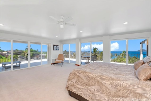 carpeted bedroom with access to outside, ceiling fan, and a water view