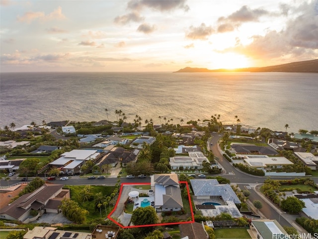 aerial view at dusk featuring a water view