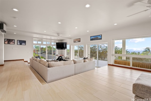 living room with ceiling fan and light hardwood / wood-style flooring