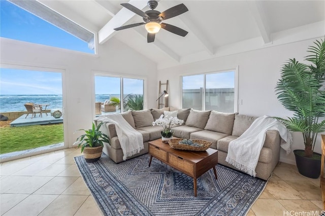 interior space with light tile patterned floors, ceiling fan, beam ceiling, a water view, and a healthy amount of sunlight