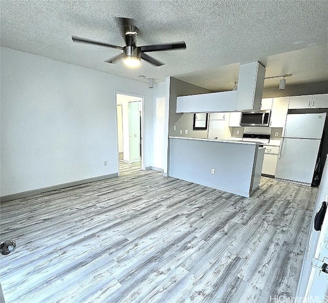 kitchen with a textured ceiling, ceiling fan, white refrigerator, light hardwood / wood-style floors, and white cabinetry