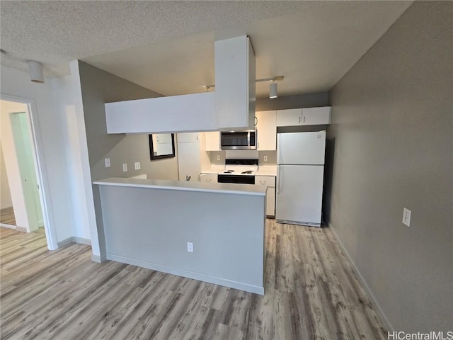 kitchen featuring kitchen peninsula, a textured ceiling, white appliances, white cabinets, and light hardwood / wood-style floors