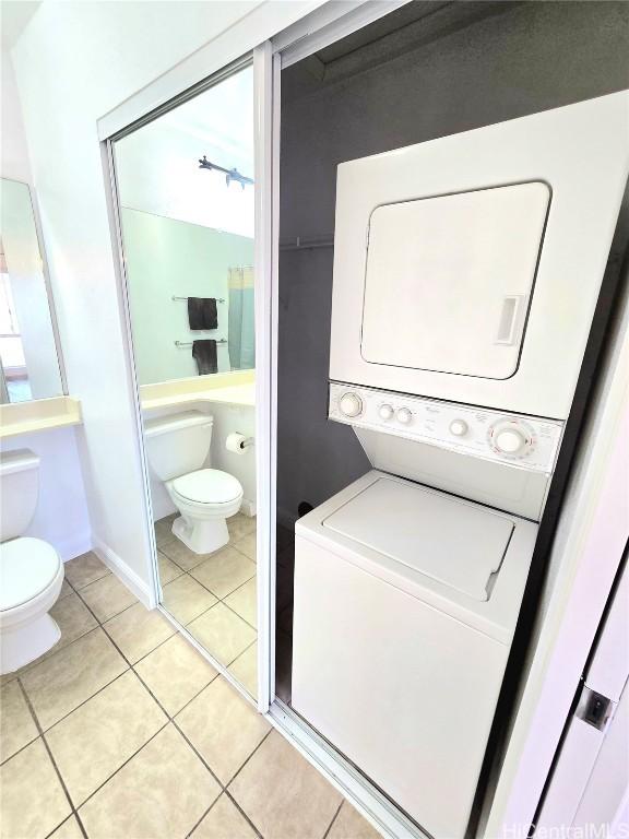 washroom featuring light tile patterned floors and stacked washer / drying machine