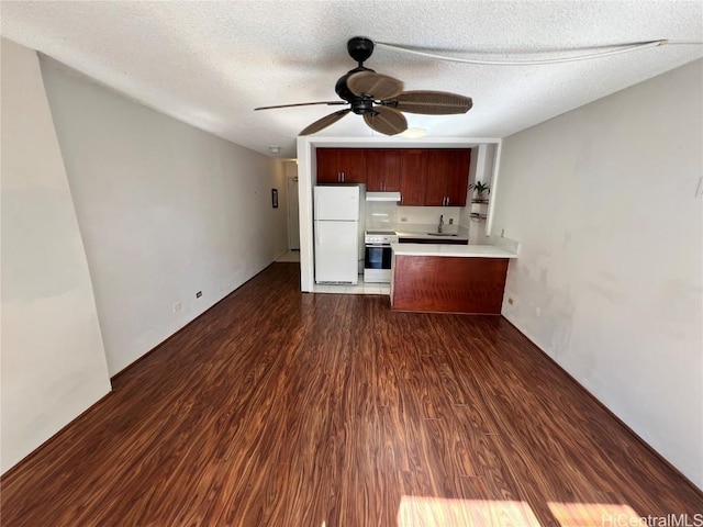 kitchen featuring dark hardwood / wood-style floors, white fridge, stove, ceiling fan, and a textured ceiling