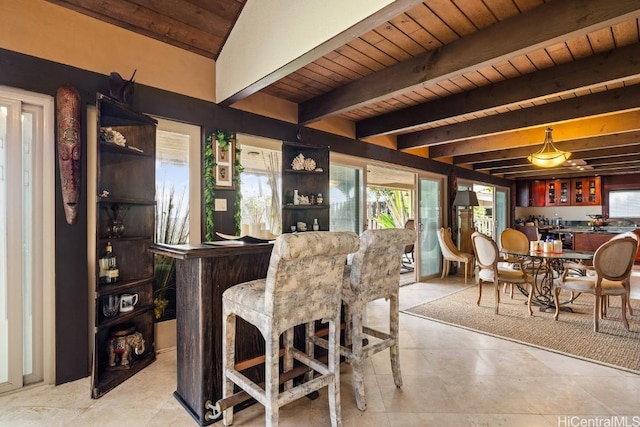 dining area featuring beamed ceiling, wooden ceiling, and indoor bar