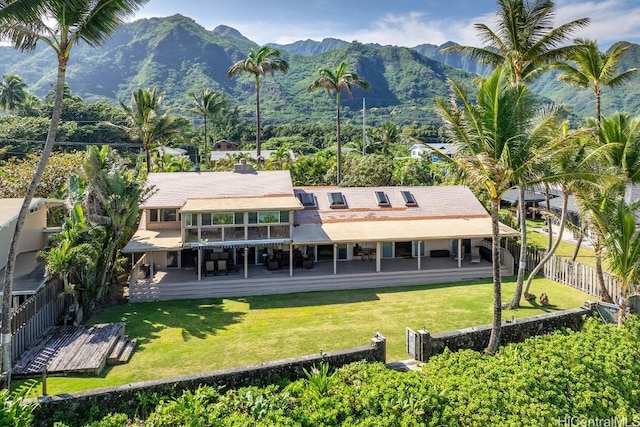 back of property with a yard and a deck with mountain view