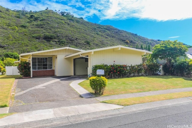 ranch-style house with a mountain view, a front yard, and a carport