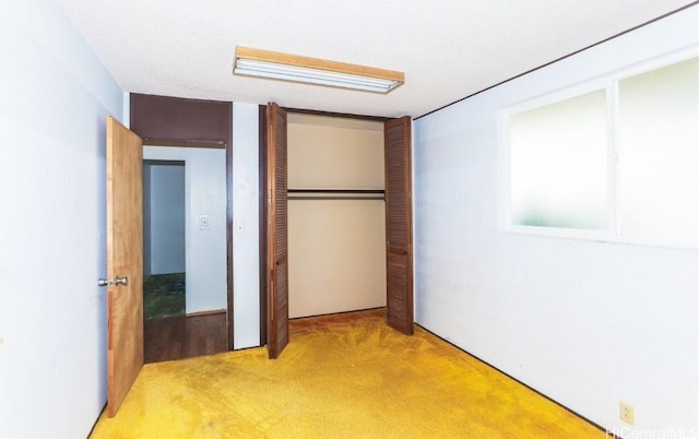 unfurnished bedroom featuring light carpet and a closet