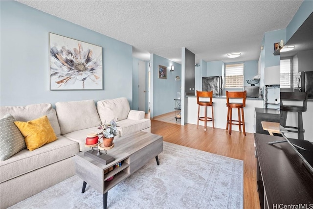 living room with light hardwood / wood-style floors and a textured ceiling