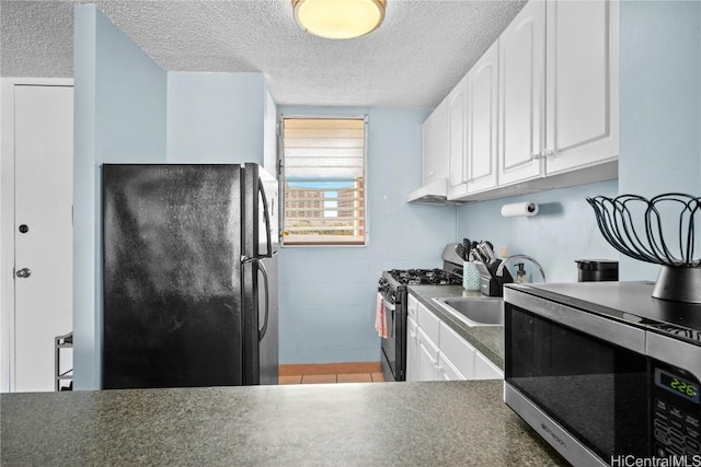 kitchen featuring electric range, sink, a textured ceiling, black refrigerator, and white cabinets