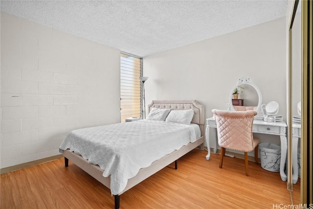 bedroom with hardwood / wood-style floors and a textured ceiling