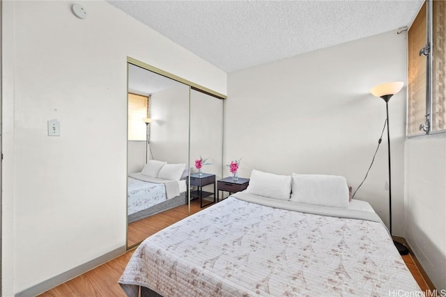 bedroom with wood-type flooring and a textured ceiling