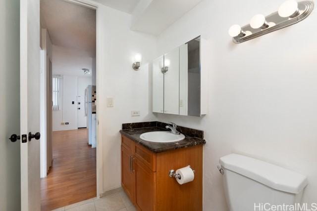 bathroom featuring tile patterned flooring, vanity, and toilet